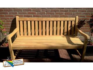 In de leuning van een houten bank graveren